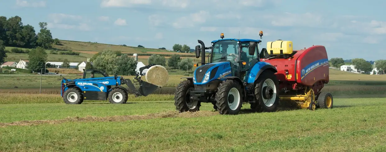 T5 Series tractor in the field next to a TH Series telehandler